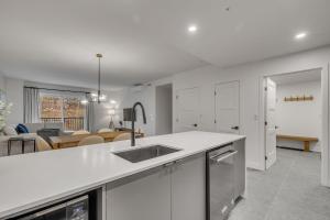 a kitchen with a sink and a living room at Initial - Mountain 302 - Ski-in-out MSA in Beaupré +41 photos