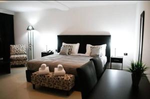 een slaapkamer met een bed, een bank en een stoel bij Hotel Solar Norte in San Miguel de Tucumán