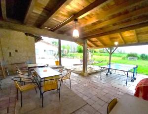 a patio with tables and chairs and ping pong tables at La Maison Pop-70's-Spot Nature-B&B in Sarrant