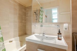 une salle de bain avec un lavabo, une baignoire et un miroir dans l'établissement Heart of Paris III, Le Marais - Charming Apartment, à Paris