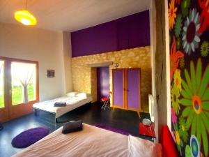 a bedroom with two beds and a colorful wall at La Maison Pop-70's-Spot Nature-B&B in Sarrant +258 photos
