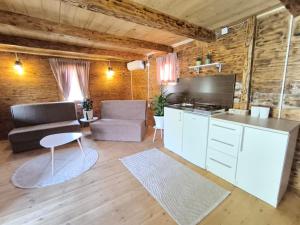 a kitchen and living room with a couch and a table at Wooden Lakeside Cottage in Virpazar
