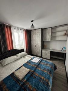 a bedroom with a bed with a blanket and a desk at 1977 GUEST house in Karakol