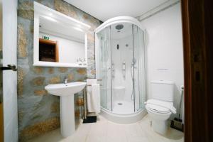a bathroom with a shower and a toilet and a sink at Alojamento Galerias Nascentes in Alijó