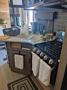 a kitchen with a stove and a sink with towels at Beachfront Camper, Bahia Turquesa BCS in La Ventana
