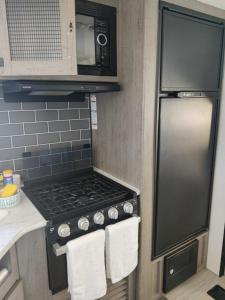 a kitchen with a stove and a microwave at Beachfront Camper, Bahia Turquesa BCS in La Ventana