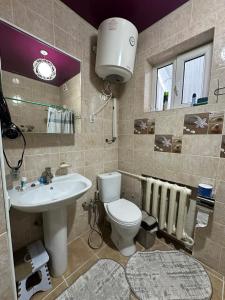 a bathroom with a white toilet and a sink at 1977 GUEST house in Karakol +26 photos