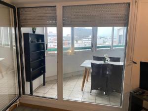 a room with a table and a window with blinds at Les Trois koush in Courcouronnes +19 photos