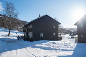 a person standing in the snow in front of a building at Alpinlandsbyen - Ski in - Ski out -Nr 34 in Hafjell