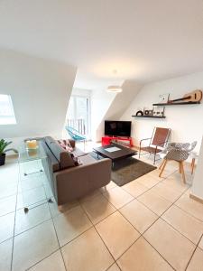 a living room with a couch and a table at Les diablotines - 6 couchages 2 sdb - proche plage in Cabourg