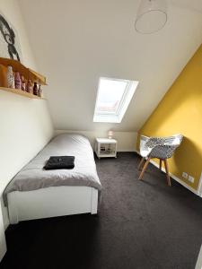 a bedroom with a bed and a window and a chair at Les diablotines - 6 couchages 2 sdb - proche plage in Cabourg