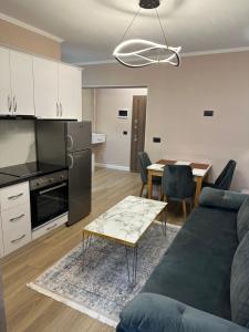 a kitchen and living room with a couch and a table at Isea Studio Apartment in Korçë