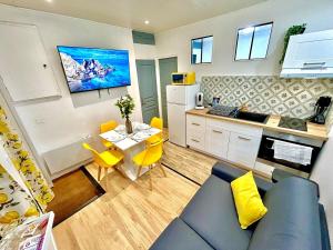 ein Wohnzimmer mit einer blauen Couch und einer Küche in der Unterkunft Le Zeste, centre parking gratuit in Villeneuve-sur-Yonne + 22 Fotos