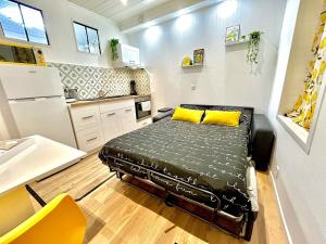 ein kleines Zimmer mit einem Bett in einer Küche in der Unterkunft Le Zeste, centre parking gratuit in Villeneuve-sur-Yonne