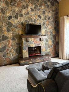 a living room with a stone wall with a fireplace at Old Town in Çilǝgir