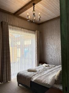a bedroom with a bed with a window and a chandelier at Old Town in Çilǝgir