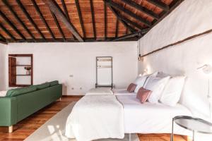 a bedroom with a bed and a green couch at Tango by Huskalia in Breña Alta