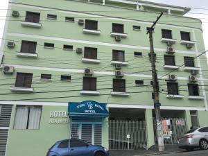 un edificio verde con un cartello hotel di fronte di Hotel Villa Brites a Mauá