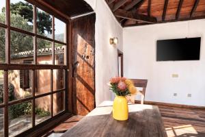 a yellow vase with flowers on a table in a room at Succession by Huskalia in Breña Alta