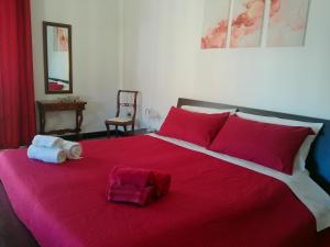 a bedroom with a red bed with two towels on it at Cappuccini apartments superior in Oristano