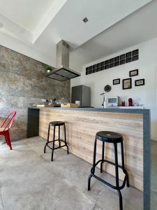 a kitchen with two stools in front of a counter at Fil Rouge in Ciampino +127 photos