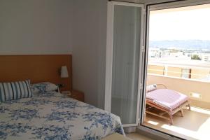 a bedroom with a bed and a balcony with a window at Ático Dos Bahías in Águilas +54 photos