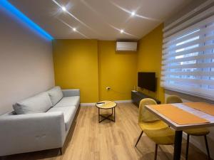 una sala de estar con un sofá y una mesa en Central Modern Apartment, en Tirana