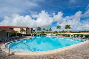 a swimming pool at a resort with chairs and palm trees at St. Augustine Ocean & Racquet Resort in St. Augustine