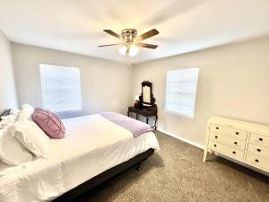 a bedroom with a bed and a ceiling fan at The Purple House - Cozy Near TSU in Stephenville