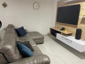 a living room with a couch and a flat screen tv at Casa campestre Magyli in Puerto Salgar