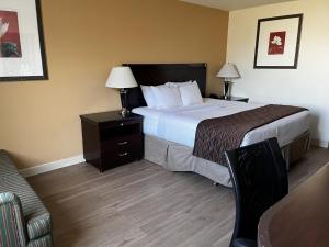 a hotel room with a bed and a chair at Budget Inn Laramie in Laramie