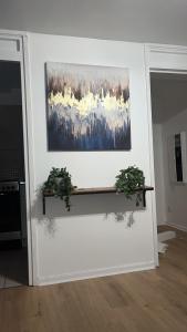 een schilderij aan de muur met twee planten bij Apartment facing Covent Garden station in Londen +24 foto's