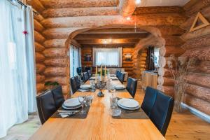 a dining room with a long table and chairs at Naturstammhaus mit Sauna, coffee and tea for free in Ölbronn-Dürrn
