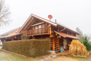 a log cabin with a porch and a fence at Naturstammhaus mit Sauna, coffee and tea for free in Ölbronn-Dürrn
