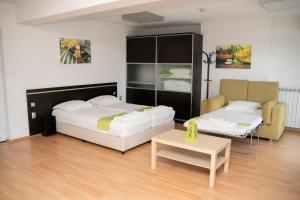 1 dormitorio con 2 camas y mesa de centro en Guest house Traikovi, en Petrich