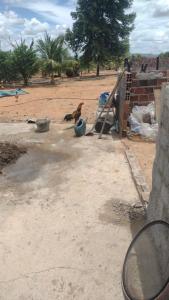 a bird is sitting on the ground next to a fence at Apartamento Sol e Lua in Lauro de Freitas