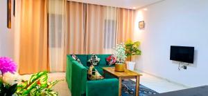 a living room with a green couch and a table at Dar Noureddine in Lalla Takerkoust