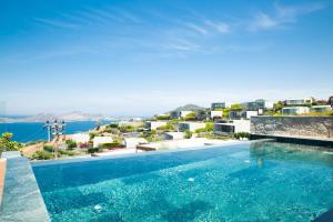 a swimming pool with a view of the ocean and buildings at Villa Calista by Important Group Travel in Yalıkavak