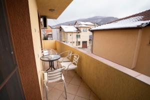 Un balcón con mesa y sillas y una vista en Guest house Traikovi, en Petrich