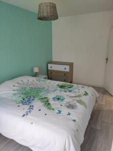 een bed met een wit dekbed met bloemen erop bij Ty Moon in Lannion +13 foto's