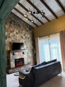 a living room with a couch and a stone fireplace at Old Town in Çilǝgir