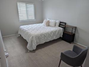 a bedroom with a bed and a chair and a window at By Popular Demand - Houston in Houston