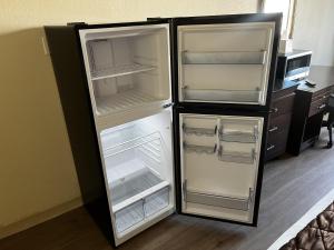 an empty refrigerator with its doors open in a room at Budget Inn Laramie in Laramie