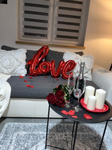 a couch with a table with a love sign on it at Ranczo pod lasem in Witnica +1 photo