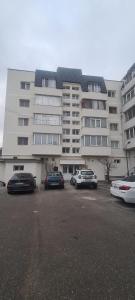 a large building with cars parked in front of it at Apartament Oașul in Negreşti-Oaş