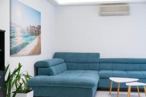 a blue couch in a living room with a table and stool at Apartment Danica in Poličnik