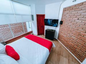 a bedroom with a brick wall and a bed and a tv at Casa Franlus Depa4 in San Cristóbal de Las Casas