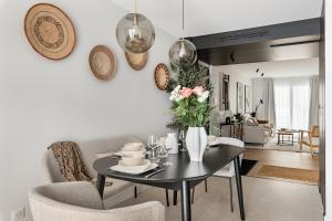 a living room with a table with a vase of flowers at La consulte - exceptional apartment in Saint-Étienne
