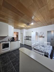 a kitchen with white cabinets and a bed in a room at Ferienhaus Luise, Kalles Ferienwohnung in Rörvik