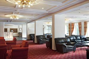 a waiting room with leather chairs and couches at TH Corvara - Greif Hotel in Corvara in Badia